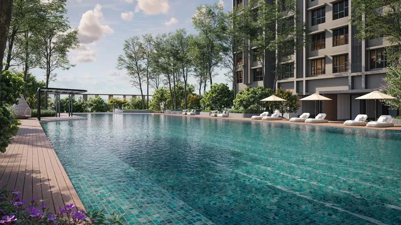 Long swimming pool with sun loungers and a residential tower behind